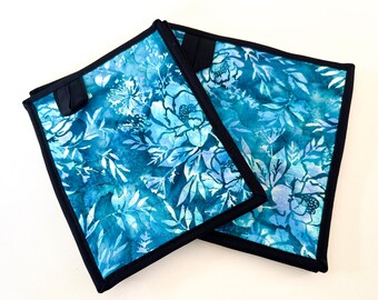 Agarraderas de tela batik acolchadas con estampado floral azul, con opción de tamaño y pestaña para colgar.