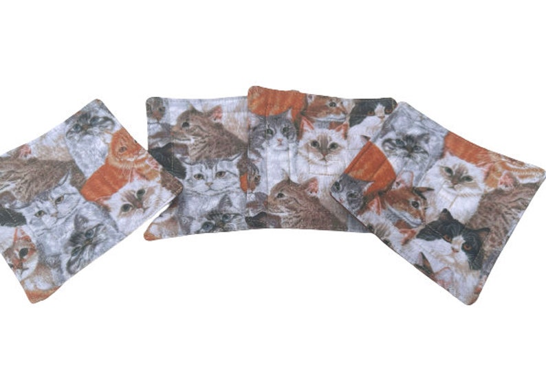 May include: Set of five gray and white fabric coasters with a colorful cat print. The coasters feature a variety of cat breeds with different fur patterns and colors.