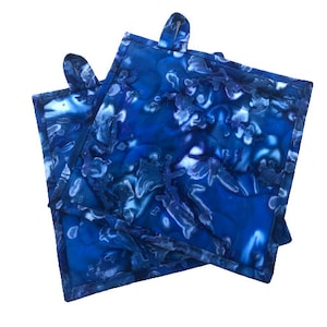 May include: Two blue and white patterned pot holders with a tie-dye design. The pot holders have a loop on each corner.