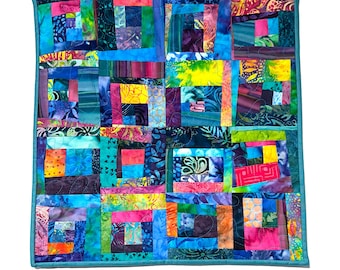 Edredón de patchwork de tela batik de colores para usar como adorno de mesa o para colgar en la pared.