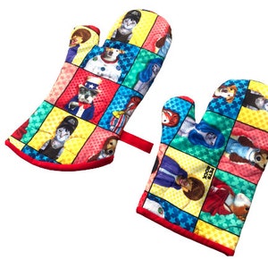 May include: A pair of red oven mitts with a colorful patchwork design featuring cartoon dogs and cats wearing different costumes. The mitts have a red trim and the text "Pets Rock" is visible on one mitt.