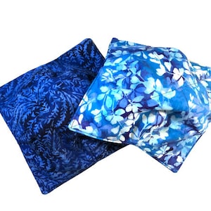 May include: Two blue fabric squares with a leaf pattern. The squares are quilted and have a white background with blue leaves.