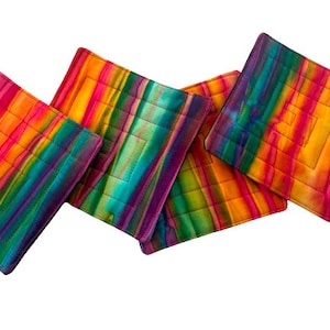 May include: Set of four colorful quilted fabric coasters with a rainbow stripe pattern. The coasters are made of a soft, absorbent fabric and are perfect for protecting your furniture from heat and spills.