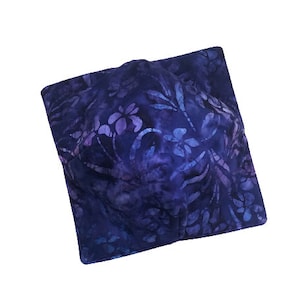 May include: A blue and purple fabric pillow with a floral pattern.