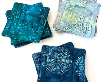 Posavasos acolchados de tela batik azul y verde, juegos de cuatro, con lunares y espirales.