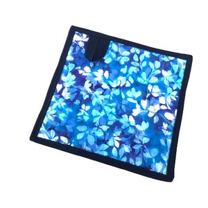 Peut inclure: Porte-pot en tissu imprimé de fleurs bleues et blanches avec une bordure bleu foncé.