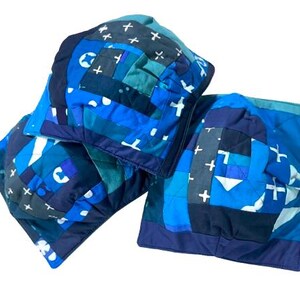May include: Three blue and white patterned throw pillows with a patchwork design. The pillows are made of different fabrics and have a variety of textures.