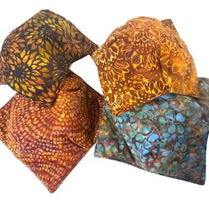 May include: Four square fabric pillows with different batik patterns in shades of brown, orange, yellow, blue and green.