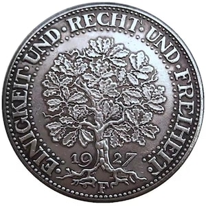 May include: A silver coin featuring a detailed oak tree design at the center, with the year 1927 below. The coin's edge is inscribed with the words "EINIGKEIT UND RECHT UND FREIHEIT" in a circular pattern.