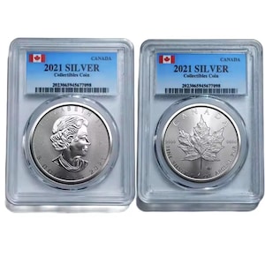 May include: Two silver Canadian collectible coins in protective cases. One coin features a profile of Queen Elizabeth II, the other a maple leaf. Each case has a label with "2021 SILVER" and a serial number.