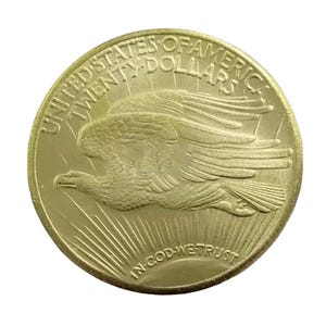 May include: A gold-colored United States twenty dollar coin with an eagle in flight and the words "United States of America Twenty Dollars" and "In God We Trust" inscribed on it.