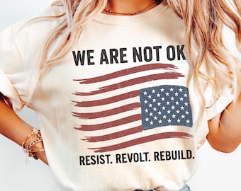 Camiseta de protesta con la bandera estadounidense desgastada: No estamos bien, resiste