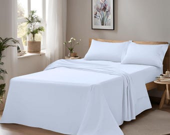 Könnte beinhalten: Ein Bett mit weißen Laken und Kissenbezügen. Das Bett ist gemacht und bezugsfertig. Der Raum hat ein Fenster und ein gerahmtes Bild. Das Bett ist aus Holz.