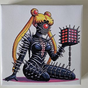 May include: A square canvas print featuring a pixelated illustration of a character in a black, spiked outfit, holding a red, glowing cube. The character has blonde hair and a mask-like face, with a red gem on the forehead.