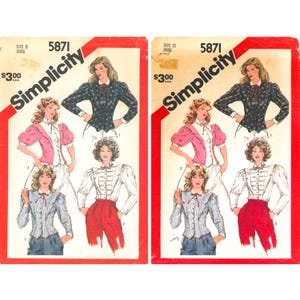 May include: Two identical Simplicity sewing pattern envelopes numbered 5871, size 12. The covers feature illustrations of three different blouse styles with puff sleeves, collars, and ties, displayed in black, pink, white, and blue patterns.