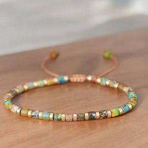 May include: A multi-colored beaded bracelet with a sliding knot closure. The beads are small and round, and they are made of a variety of materials, including glass, metal, and stone. The bracelet is a beautiful and unique piece of jewelry that would make a great gift for any occasion.