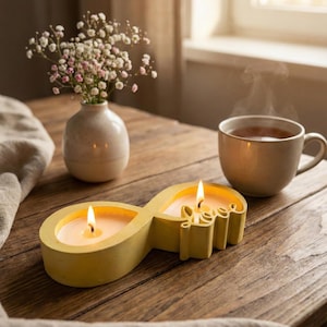 Könnte beinhalten: Ein Set aus drei Keramikbechern mit gesprenkelter, matter Oberfläche. Die Becher sind in Creme-, Hellgrau- und Dunkelgrautönen gehalten. Jeder Becher hat ein schlichtes, minimalistisches Design, ideal für Kaffee oder Tee.
