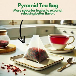 May include: A pyramid-shaped tea bag filled with loose leaf tea sits on a white plate. The tea bag is made of a white mesh material and is filled with red and green tea leaves. The tea bag is sitting on a white plate with a gold rim. The plate is sitting on a white countertop. The text "Pyramid Tea Bag" is written in green letters on a beige background above the image. The text "More space for leaves to expand, releasing better flavor." is written in green letters on a beige background below the image.