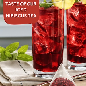 May include: Two glasses of iced hibiscus tea with lemon wedges and ice cubes. The text "Savor the refreshing taste of our iced hibiscus tea" is displayed on a red background.