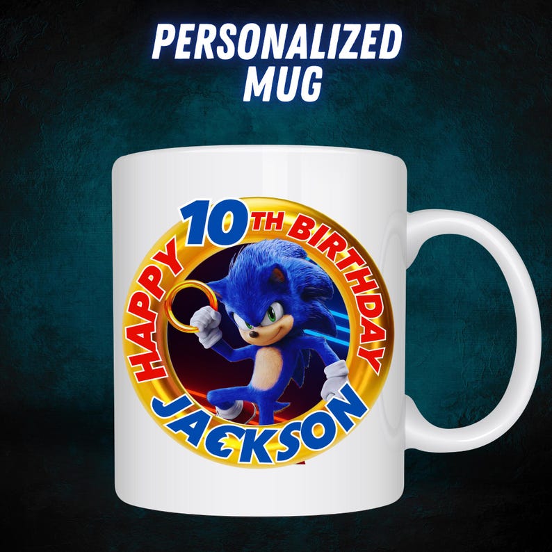 Op de afbeelding: Witte keramische mok met een gouden cirkelontwerp met een blauw Sonic the Hedgehog-personage. De cirkel zegt "Happy 10th Birthday Jackson".