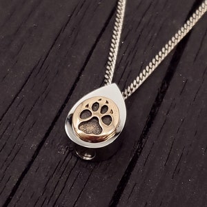 My dog track cremation urn pendant is made of hypoallergenic stainless steel with a mirror finish. Mounted on the front is my tiny solid bronze paw print. A discreetly placed screw can be removed from the bottom.