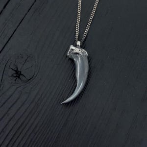Colgante bicolor con forma de garra de lobo ártico en plata de ley maciza.