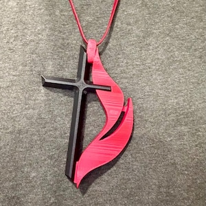 May include: A red and black pendant necklace featuring a cross and a flame. The pendant is made of plastic and is worn on a red cord.
