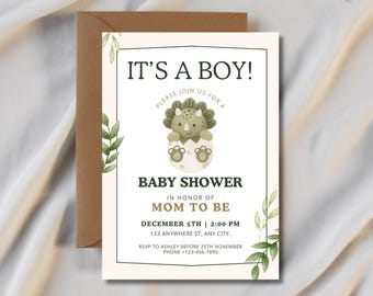 Op de afbeelding: Een uitnodigingskaart voor een babyshower met een aquarelillustratie van een groene triceratops die uit een ei komt. De tekst luidt IT'S A BOY! BABY SHOWER IN HONOR OF MOM TO BE, met datum, tijd, locatie en RSVP-details in donkergroen.