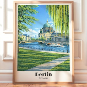 May include: A framed print of Berlin, Germany, featuring a detailed illustration of the Berliner Dom, a river, and a bridge. The artwork has a vintage travel poster style, with the city name and country at the bottom.