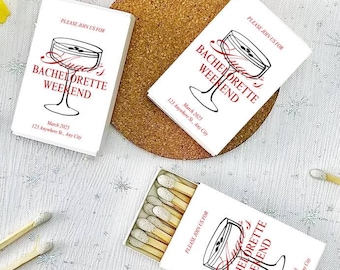 May include: White matchboxes with a black and red design. The matchboxes have a graphic of a martini glass and the text "Please join us for Bachelorette Weekend" with the date and location.