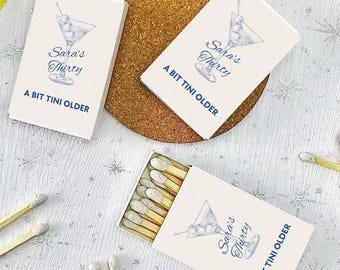 May include: Three matchboxes with a white background and blue text. Each box features a martini glass illustration and the text "Sara's Thirty" and "A Bit Tini Older".
