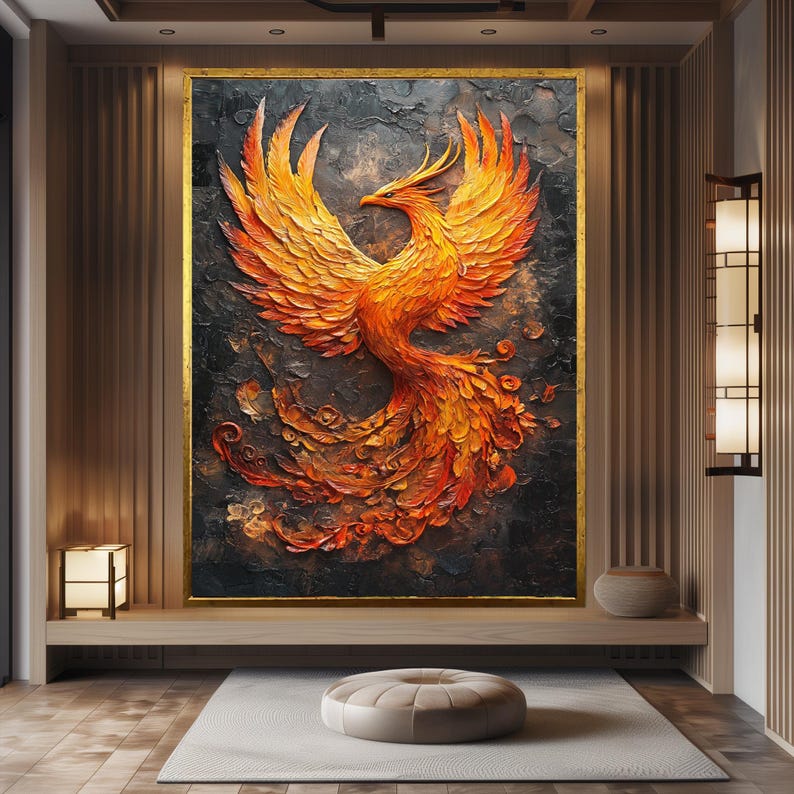 May include: A large, framed artwork depicting a phoenix in flight. The bird is rendered in shades of orange, yellow, and red against a dark, textured background. The artwork is framed in gold and hangs in a modern, minimalist interior.