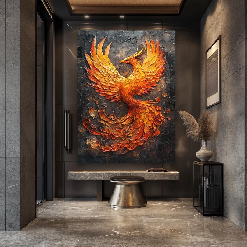 May include: A large, textured wall art piece depicting a phoenix in shades of orange and red against a dark gray background. The artwork is mounted on a wall in a modern interior setting, with a bench and stool below.