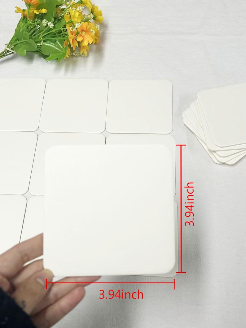 May include: A set of 10 white square coasters, each measuring 3.94 inches by 3.94 inches. The coasters are made of a smooth, white material and are perfect for protecting surfaces from spills and scratches.