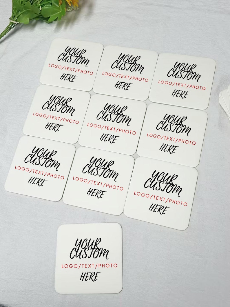 May include: Ten white square coasters with black text that reads "Your Custom" and "Logo/Text/Photo Here".