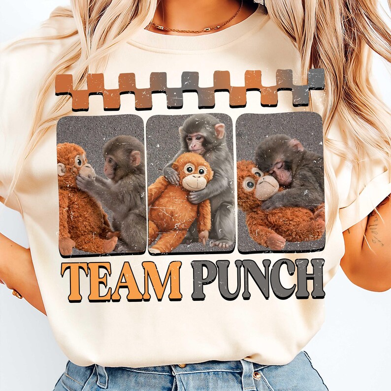 以下が含まれることがあります： 3匹の猿とぬいぐるみ猿のグラフィックが特徴のクリーム色のTシャツ。「TEAM PUNCH」の文字がオレンジとグレーでグラフィックの下にプリントされています。