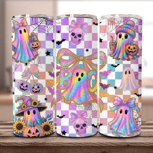 May include: Three Halloween-themed tumblers with a checkered background. The designs feature ghosts, pumpkins, bats, and skulls in a rainbow holographic style. The word "BOO" is prominently displayed on one tumbler.