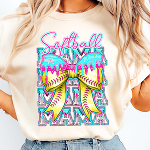 Könnte beinhalten: Cremefarbenes T-Shirt mit einem Softball-Motiv. Das Design zeigt die Worte "Softball Mama" in einem sich wiederholenden Muster, mit einer großen gelben Schleife, die einem Softball ähnelt. Die Schleife hat blaue und rosa Akzente mit einem Tropfeffekt.