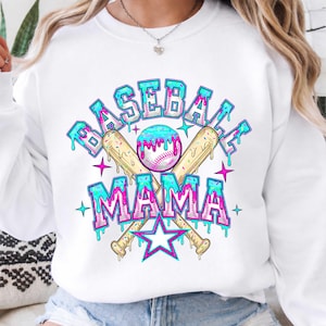 May include: White sweatshirt with a colorful baseball-themed graphic. The design features the words "BASEBALL MAMA" in a dripping, bubble-letter style, along with a baseball, crossed bats, and stars. The graphic is in shades of blue, pink, and yellow.