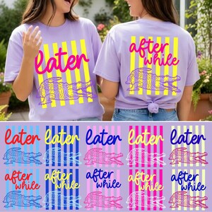 May include: Two lavender t-shirts with a graphic of an alligator and the words "later" and "after while" in pink and yellow. The alligator design is purple and yellow. Below are various designs of the same shirt.