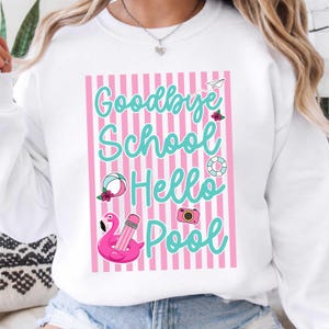 May include: White sweatshirt with a pink and white striped design. The sweatshirt features the text "Goodbye School Hello Pool" in turquoise script, along with summer-themed graphics like a flamingo, beach ball, and camera.
