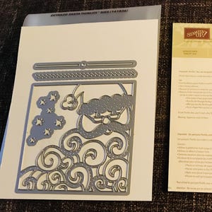 May include: A die-cut set featuring a Santa Claus design with swirling patterns, stars, and a beard. The set includes additional decorative elements. A paper with the text "Big Shot" is also present.