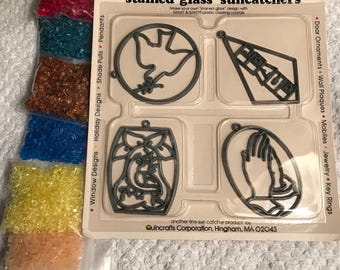 May include: A craft kit with the text "Omakit & Bakit" and "stained glass suncatchers." The kit includes various suncatcher designs and small bags of colorful beads in red, blue, brown, yellow, and orange.
