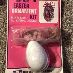 May include: A pink and white Easter ornament craft kit with all materials included. The kit includes a styrofoam egg, pink and white ribbon, sequins, and pink flowers. The kit is easy to make and is perfect for decorating your home for Easter.