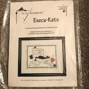 May include: A counted cross stitch pattern featuring a cartoon illustration of three cats working in an office. The pattern is titled "Execu-Kats" and is adapted from the artwork of Kathleen Kelly of Kats by Kelly. The pattern is by Calico Crossroads.