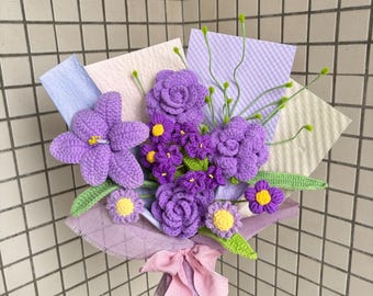 May include: A handmade bouquet of crocheted flowers in shades of purple, lavender, and yellow. The bouquet includes various flower types, green leaves, and stems, wrapped in lavender paper and tied with a pink ribbon. The background includes light blue, pink, and lavender paper.
