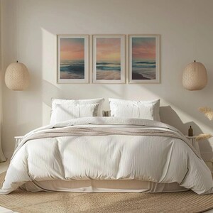 Puede incluir: Una cama blanca con un edred&oacute;n blanco y dos almohadas blancas. Tres cuadros enmarcados de escenas oce&aacute;nicas cuelgan sobre la cama. Los cuadros est&aacute;n en fila y todos son del mismo tama&ntilde;o. La habitaci&oacute;n est&aacute; decorada con un estilo minimalista con una pared beige claro y una alfombra tejida en el suelo.