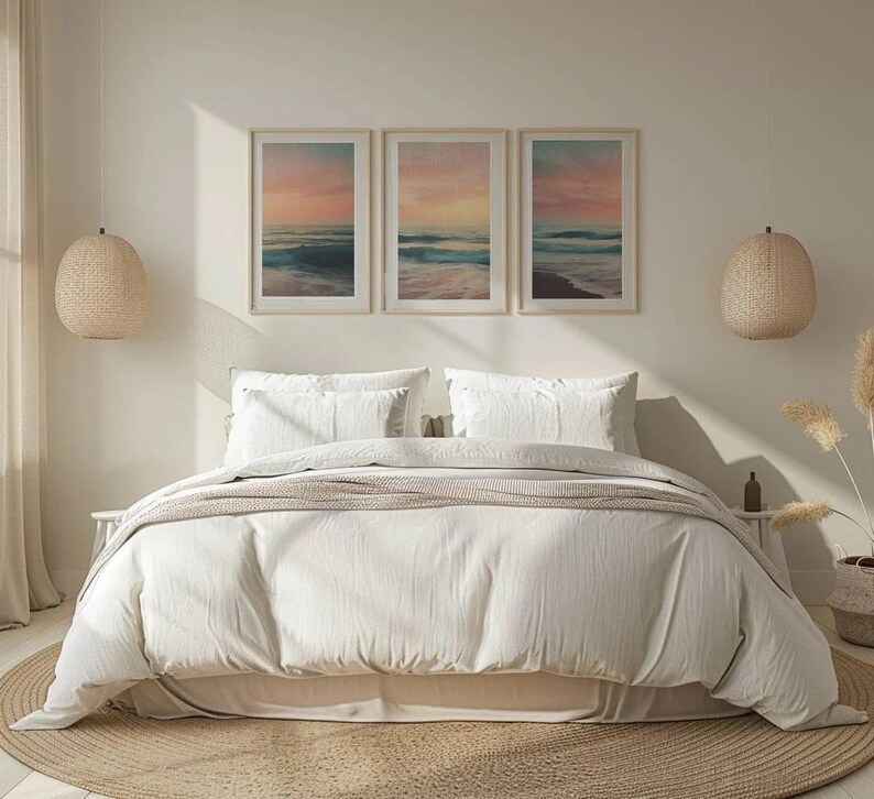 Puede incluir: Una cama blanca con un edred&oacute;n blanco y dos almohadas blancas. Tres cuadros enmarcados de escenas oce&aacute;nicas cuelgan sobre la cama. Los cuadros est&aacute;n en fila y todos son del mismo tama&ntilde;o. La habitaci&oacute;n est&aacute; decorada con un estilo minimalista con una pared beige claro y una alfombra tejida en el suelo.