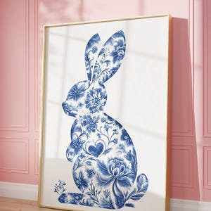 May include: A blue and white floral patterned rabbit silhouette art print in a gold frame. The rabbit is sitting upright with its ears up and a small heart in the center of its chest.