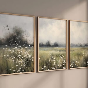 May include: Three framed landscape paintings with a muted colour palette. The paintings depict a field of wildflowers with a hazy background.